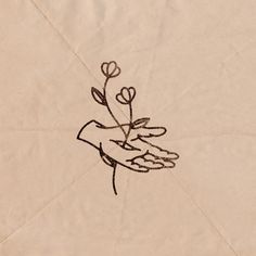 a drawing of a hand holding a flower on top of a piece of parchment paper