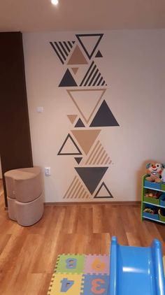 a child's playroom with wooden floors and wall art