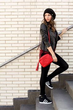 a woman in black and red is standing on some steps