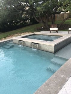 an empty swimming pool surrounded by trees and lawn chairs in the back yard with no one around it