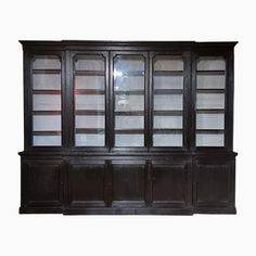 an old wooden bookcase with glass doors on the top and bottom, against a white background