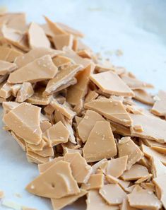 a pile of peanut butter pieces on top of a white countertop next to a knife