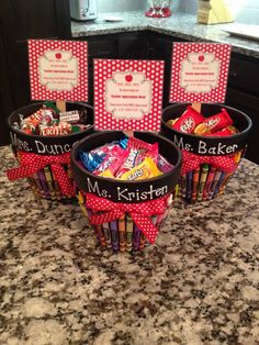 three baskets filled with candy sitting on top of a counter next to cards and envelopes