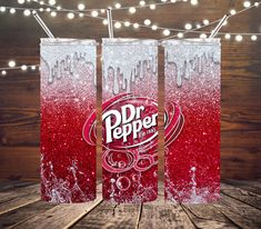 three dr pepper soda cans with lights in the background