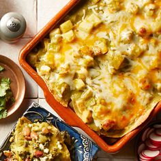 a casserole dish with meat and vegetables in it on a table next to other dishes