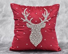 a red pillow with a stag head on the front and white polka dots on the back