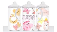 three sippy cups with different designs on them, one is pink and the other is white