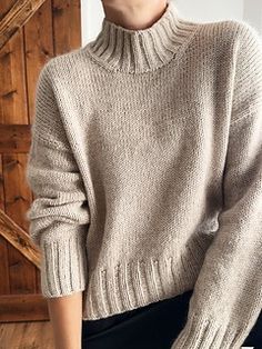 a woman wearing a turtle neck sweater and black pants