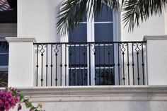 a balcony with wrought iron balconies and palm trees in front of the building