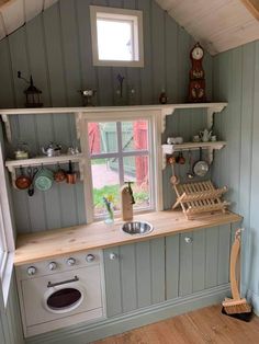 a small kitchen with wooden floors and shelves on the wall, along with an open window