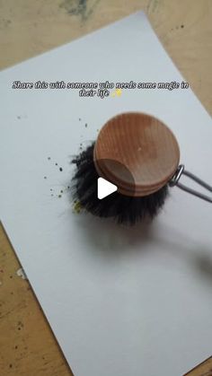 a wooden brush with black bristles on top of a piece of paper that says, what does this mean?