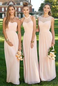 three beautiful women in long dresses posing for the camera