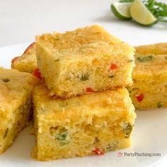 several pieces of cornbread on a white plate with green garnish around it