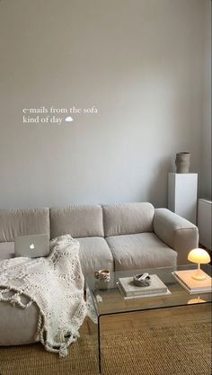 a living room with a couch, coffee table and laptop