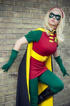 a woman in a costume is leaning against a brick wall and posing for the camera