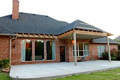 a brick house with an attached porch and covered patio