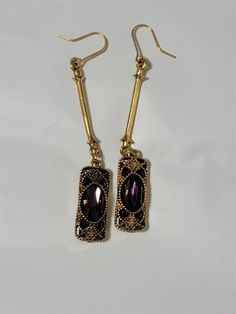 Victorian Trading Gold Baroque Filigree Drop Earrings Purple Stones 30W From The Victorian Trading Company: Baroque Rhinestone Dangle Drop Luminous, rhinestones dangle from elegant filigree cages 2.5"  Surgical steel hook Made in the USA Antique Gold color metal Free Shipping   Contact Us: For eBay customer service inquiries, please message us through eBay messaging OR  at 18889151535   Powered by SixBit's eCommerce Solution