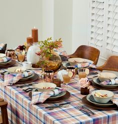 the table is set with plates, cups and utensils