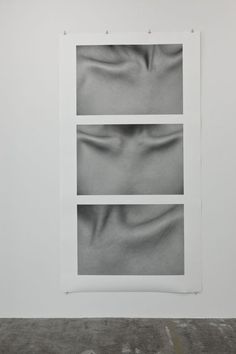 two black and white photographs hanging on a wall next to each other in an empty room