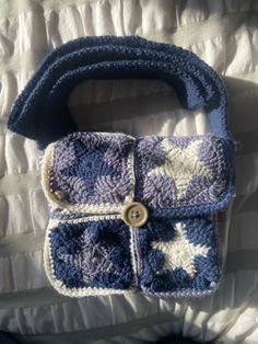 a crocheted purse sitting on top of a bed