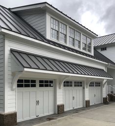 two garages with white doors and black roof