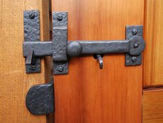 a close up of a wooden door with an iron handle on the front and side