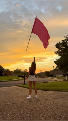 a woman holding a pink flag in the air