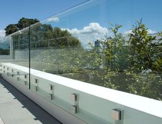 there is a glass wall on the side of this building with trees in the background