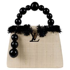 Experience a true piece of art with the Louis Vuitton ArtyCapucines PM Handbag by Jean-Michel Othoniel. Limited to only 200 bags, in this 2nd edition, the French sculptor worked with natural weaved raffia and an exquisite twisted handle adorned with oversized beads. The black resin handle and charm reflect the sculptor's iconic works, making this bag a true collector's item. Inclusion: Dust bag, display box, authenticity certificate. Handbag Display Boxes, Re Purposed Louis Vuitton, Black Louis Vuitton Bag 1stdibs, Sac Louis Vuitton, Black Louis Vuitton, French Sculptor, Louis Vuitton Capucines, It Bag, Novelty Bags