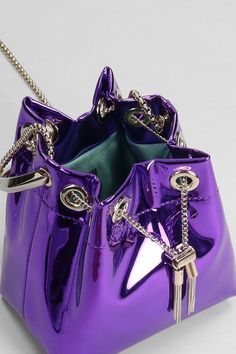 Bon Bon Hand bag in Viola leather, Width 140 mm, Height 150 mm, ring handle, chain shoulder strap, coulisse closure, liquid metal leather, gold hardware, Made in Italy | Jimmy Choo Women's Bon Bon Hand Bag in Viola Leather in Purple | FW23/24 Luxury Metallic Shoulder Bag For Evening, Luxury Gold Bucket Bag For Formal Occasions, Modern Gold Bucket Bag For Formal Occasions, Luxury Glossy Evening Shoulder Bag, Luxury Metallic Clutch Shoulder Bag, Luxury Silver Bucket Bag For Evening, Modern Bags With Chain Strap For Party, Luxury Glossy Shoulder Bag For Evening, Luxury Gold Bag With Glossy Finish