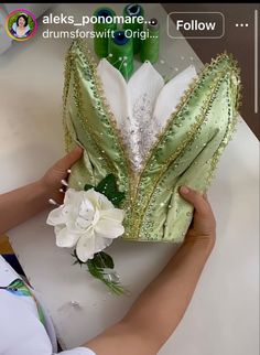 a woman is working on something with green and white flowers in front of her face