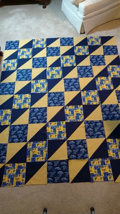 a blue and yellow quilt is laying on the floor