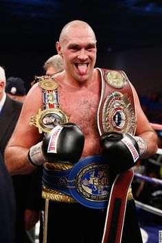 an image of a man that is holding two boxing gloves on his chest and smiling