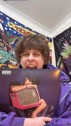 a young boy holding up an album in front of his face