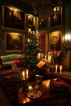 a living room with a christmas tree in the center and paintings on the wall behind it