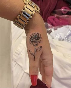 a woman's hand with a rose tattoo on it