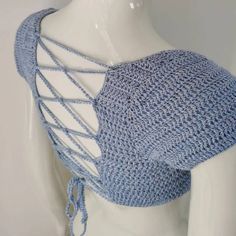 a white mannequin wearing a blue crochet top