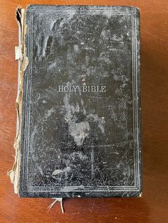 an old bible sitting on top of a wooden table