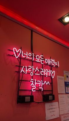 a neon sign on the side of a wall with writing underneath it that says love