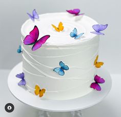 there is a white cake with butterflies on it