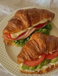 a croissant sandwich with meat, cheese and tomatoes