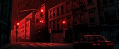 a car driving down a street at night with red lights shining on the buildings behind it