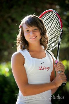 a young woman holding a tennis racquet in her hands