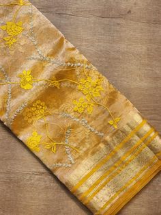 a yellow and gold saree with flowers on it