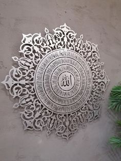 an intricately designed metal plate with the word, in arabic and english writing on it