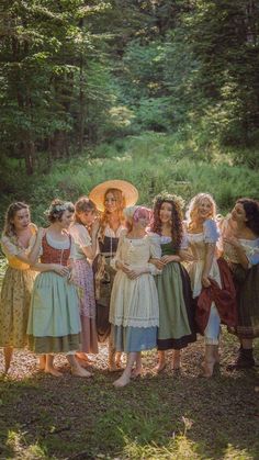 a group of women standing next to each other in the woods