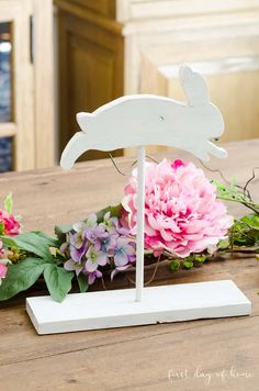 a table with flowers and a wooden sign on it