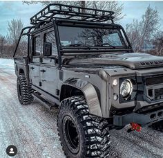 an army green hummer truck parked on the side of a road in the snow