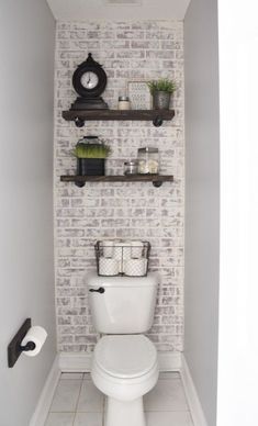 a white toilet sitting in a bathroom next to a shelf filled with towels and other items