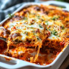 a casserole dish with meat and cheese being lifted from the casserole